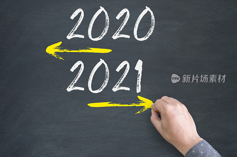 Opposite arrows with Year 2020 versus Year 2021. Hand drawing with chalk on blackboard